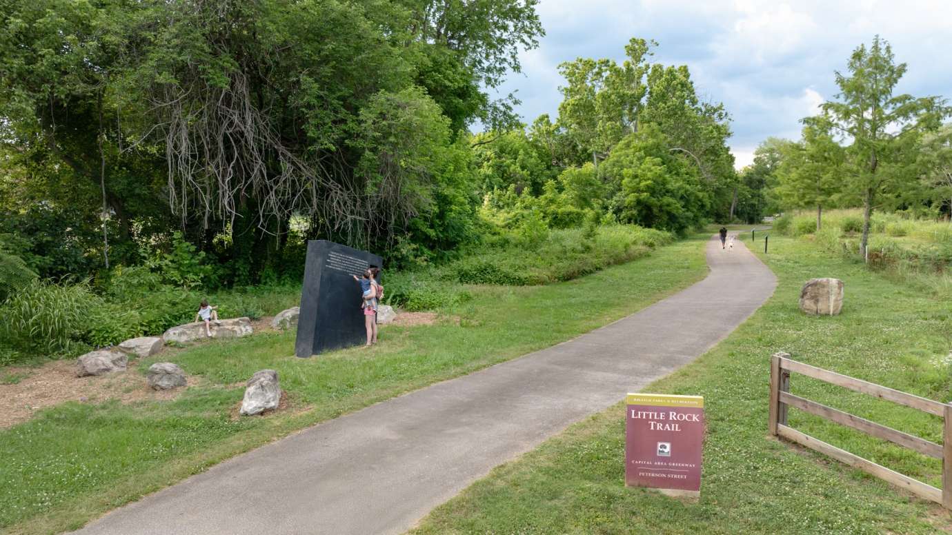 Image of a large concrete monolith sculpture with information about stormwater infrastructure printed on it.