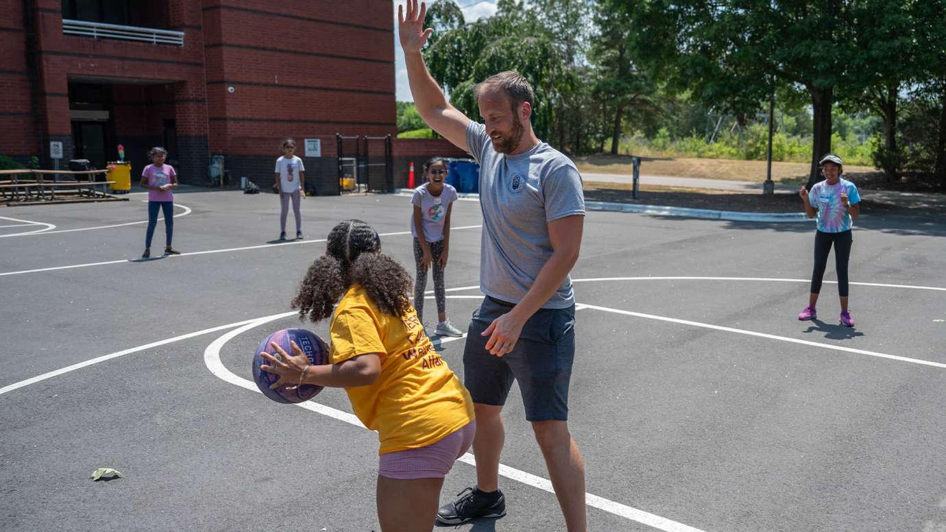 girls playing basketball with officers 