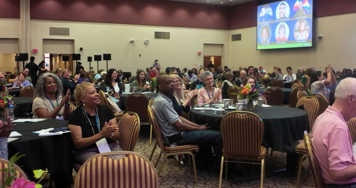 Audience pictured at tables during the keynote program