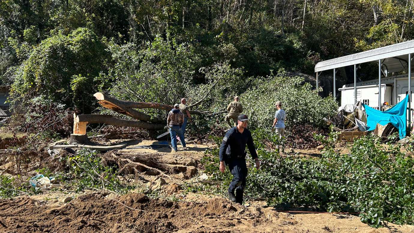 Raleigh officer walking with split huge tree behind him