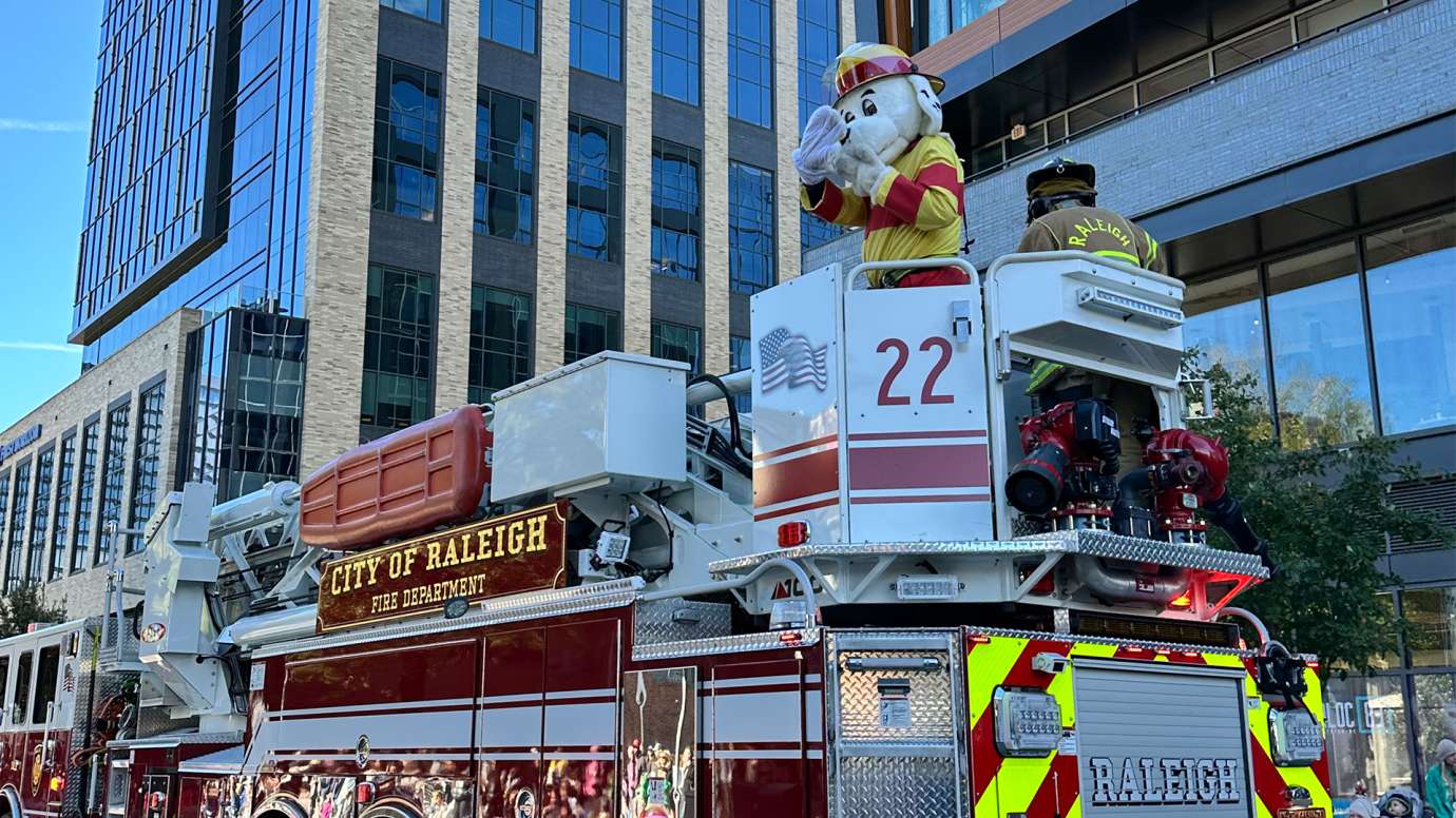 Fire Engine 22 at downtown Raleigh Christmas parade. Sparky the fire dog is waving to the crowd from the top of truck