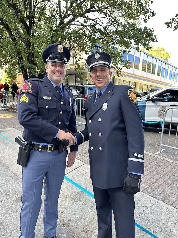 RPD officer shakes hands with a Raleigh Firefighter dressed in formal fire uniform