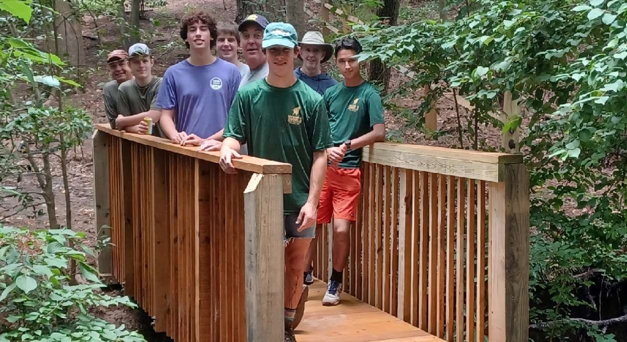 scout people on a bridge in the woods