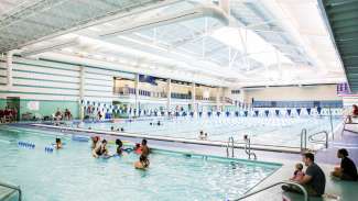 Parents and baby in the small pool at the Pullen Aquatics Center