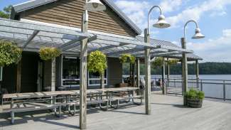 picnic tables on the deck of the watefront center with a view of lake johnson