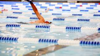 Swimmer in lap pool with arm raised mid breastroke at Pullen Park