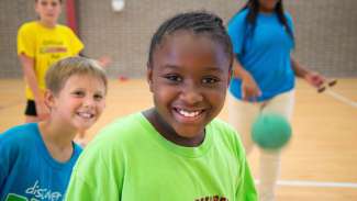 Kids smiling towards camera inside Millbrook Park gymnasium