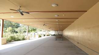 A large open lower deck below the center with ceiling fans and picnic tables