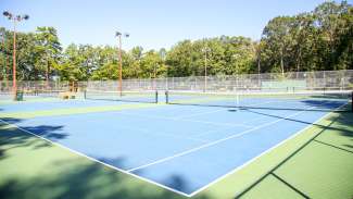 Shot of exterior tennis courts, eight total, at Optimist Park