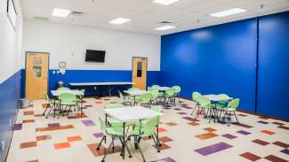 A classroom with desks and chairs 