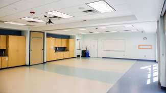 A large open meeting room with sinks, a whiteboard and counter space