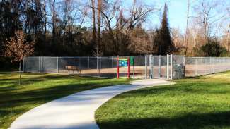 The entrance to the dog run with a wood-chip surface 