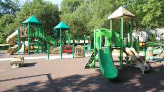 An outdoor playground with a rubber surface