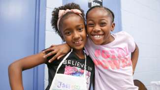 Two girls posing for a picture during a summer camp