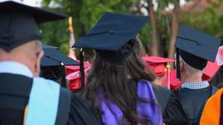 view of people sitting in gap and gowns from the back