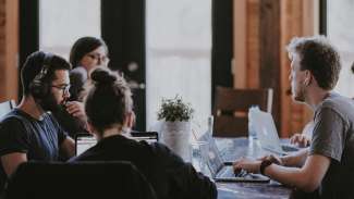 young people working on their computers around a table