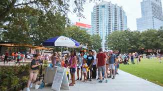 Line of customers for pushcart vendor at Moore Square