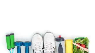 View of wellness tools from above including hand weights, tennis shoes, water bottle, jump rope and healthy salad