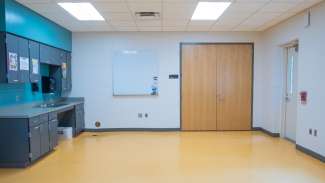 A smaller open activity room with a mounted white board and counter space