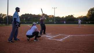 Batter ready to swing at the plate with catcher, referree and rest of players waiting