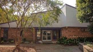 Brick community center with large tree in front