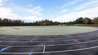 A large open field for multi-use, located in the middle of the track