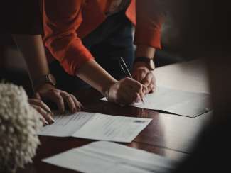 hands of woman filling out paperwork 