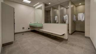 Interior of locker room with showers and bench