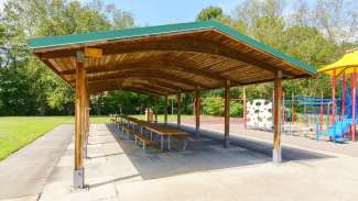 Picnic table with trees and playground in background