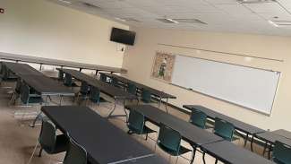 a room with table, chairs and a white board