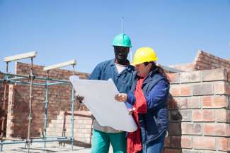 man and woman on construction site looking at site plans