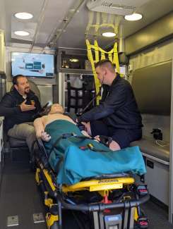 Firefighter listens to heart on a training mannequin while a training