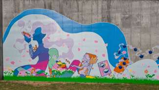 Colorful mural on a cement wall featuring an undulating wave figure