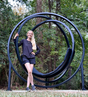 artist kathleen werner standing outside with her sculpture artwork