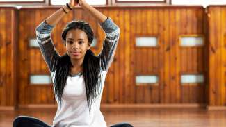 a teenager sitting on the floor in a yoga pose