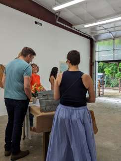 People at a gallery opening enjoying food and conversation with the artists. 