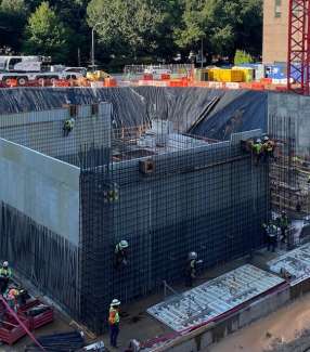 Image shows the crew installing rebar form for the new basement walls of City Hall. 