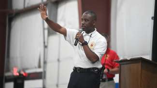 Fire Departement Chaplain speaking to Nate McMillan campers