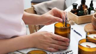 hands making a candle with fresh lavender 