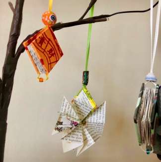 Photograph of tiny handmade books hanging on a branch.