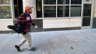 Officer W.R. Thomas walks along a Raleigh street with his backpack